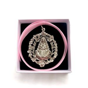 Medalla cuna de la Virgen del Rocío con motivos inspirados en filigrana. El material de fabricación es zamak.