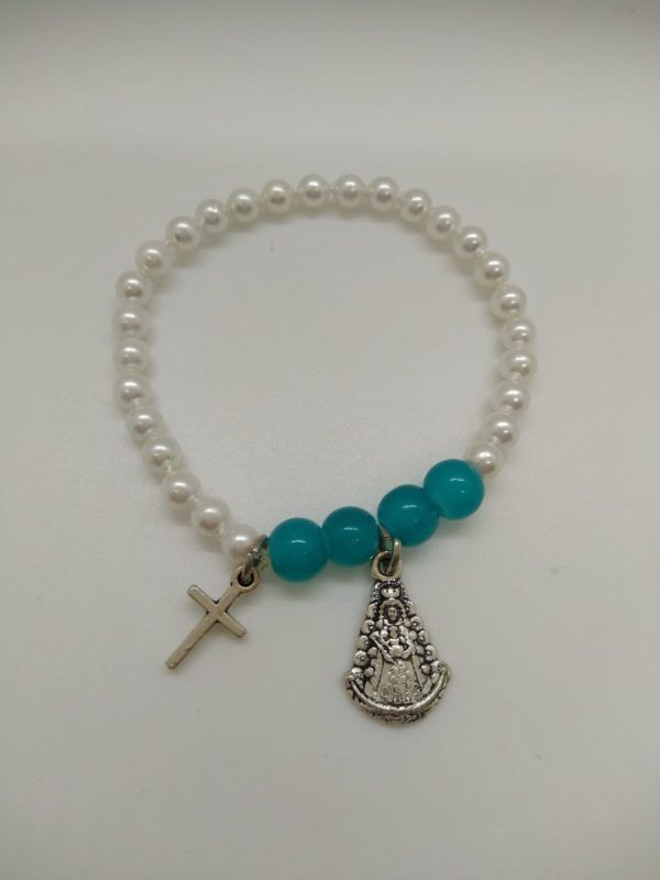 Pulsera Niña Virgen del Rocío perlas, blancas y turquesa. Medalla colgante Cruz y silueta Virgen del Rocío. Elástica y metal.