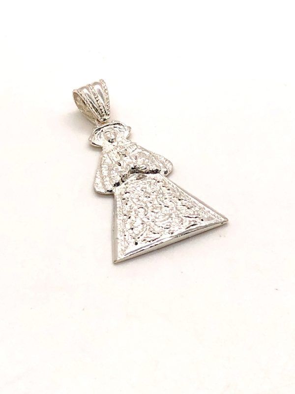 Medalla silueta Virgen del Rocío de Pastora. En la parte posterior de la medalla se encuentra grabado “Ntra. Sra. Del Rocío Patrona de Almonte”, en Plata de 1ª Ley