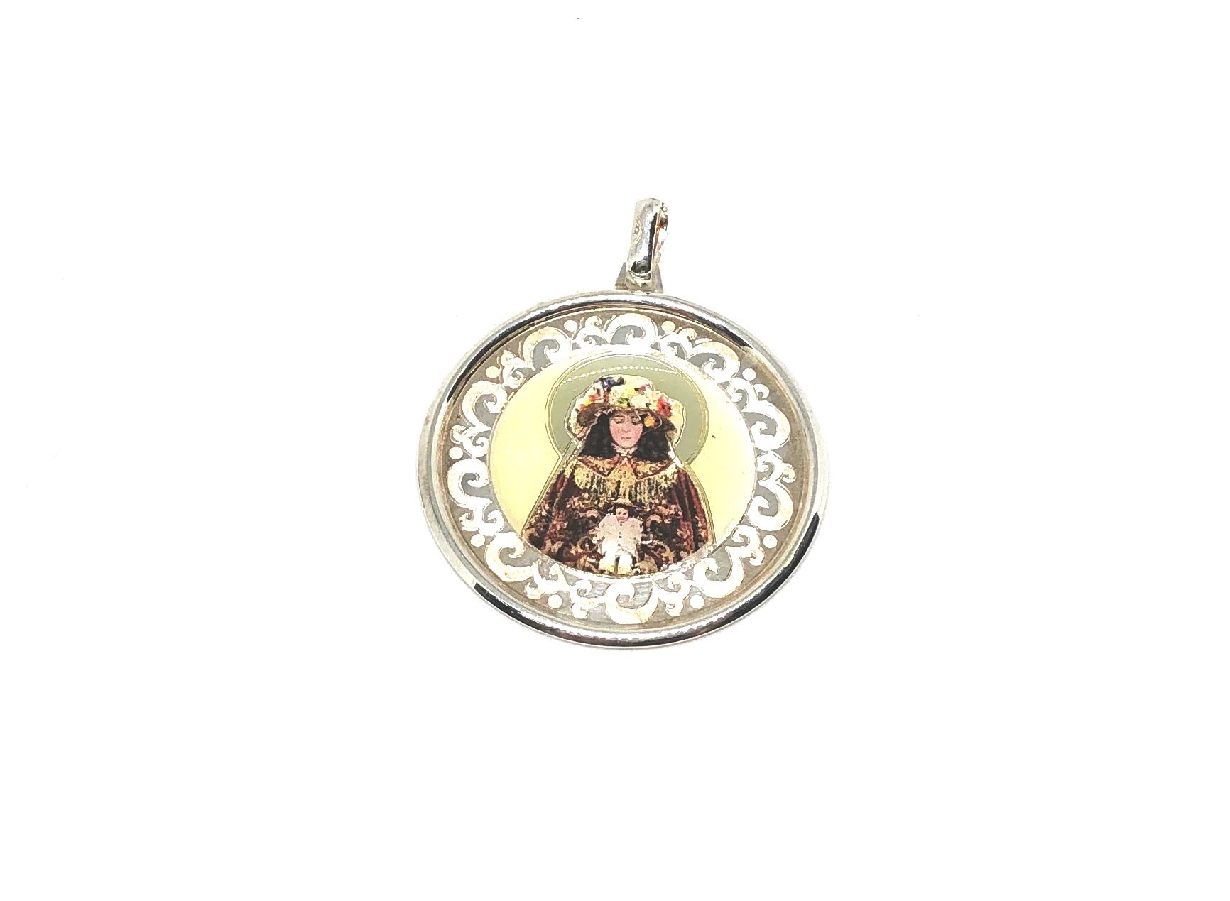 Colgante esmaltado con forma circular Virgen del Rocío con sus galas de Pastora y fabricado en Plata de 1ª Ley.